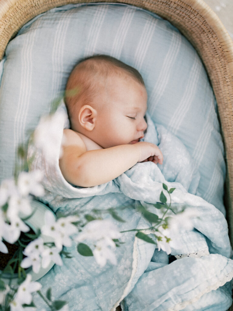 Baby sleeping in a basket at sunset